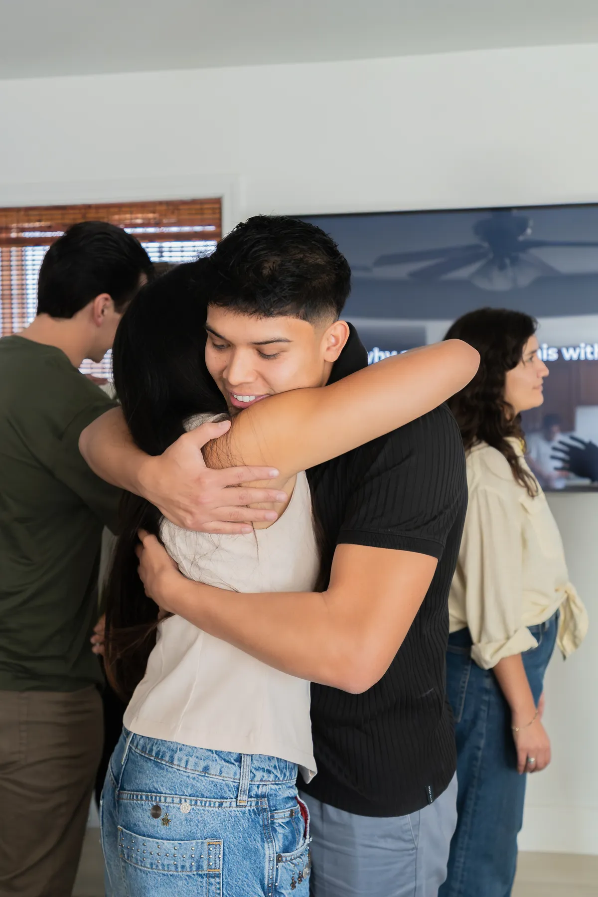 Attendees embracing, the emotional weight of the room