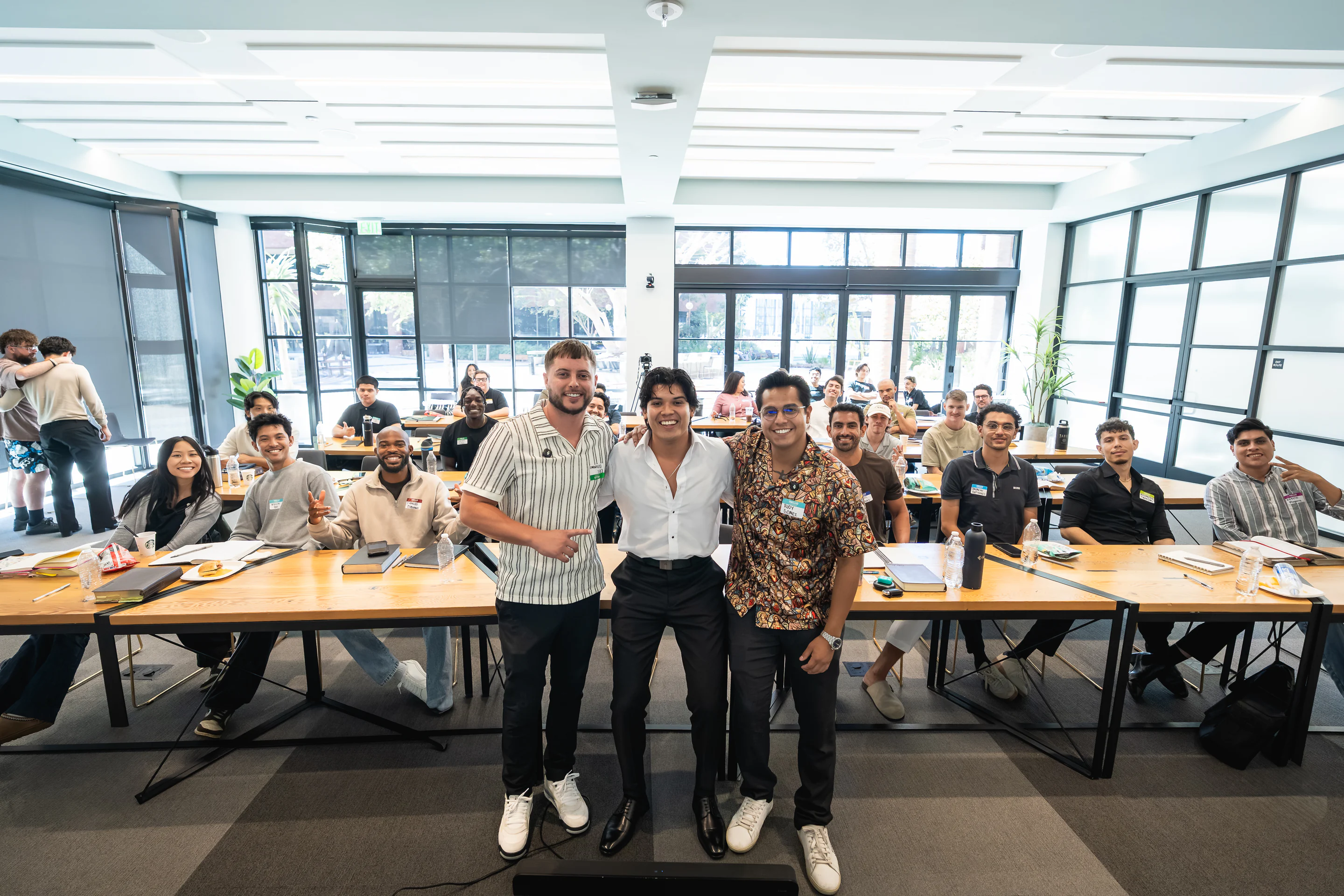 Eliam Fuentes and his guest speakers in front of a full room of leaders