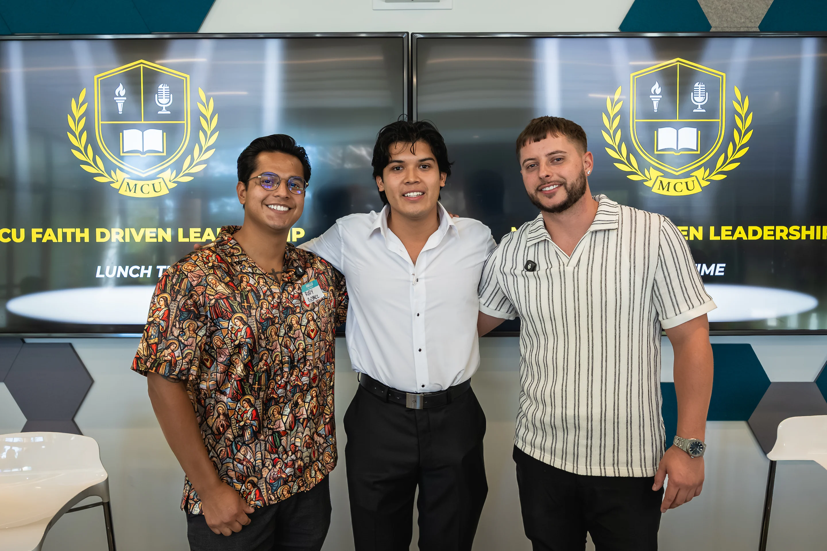 Eliam Fuentes with his guest speakers in front of the MCU Faith Driven Leadership screens