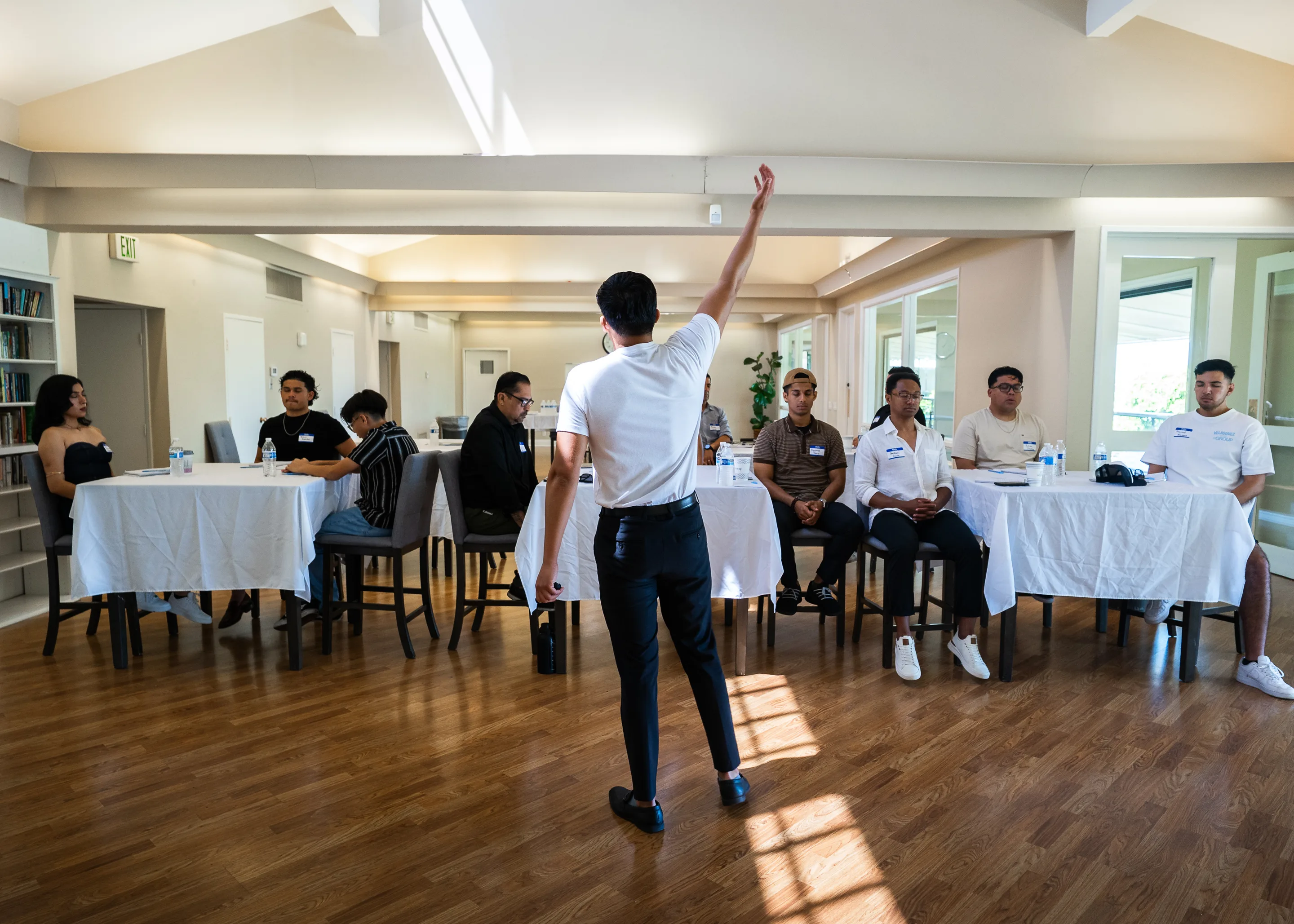 Eliam, arm raised, leading a workshop room